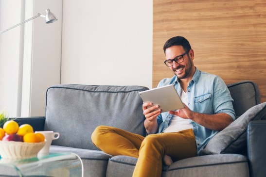 Mann mit Tablet auf einem Sofa