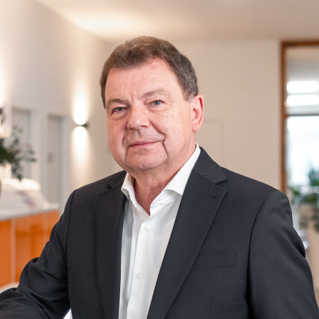 Dr. B. Knopp lehnt an Regal